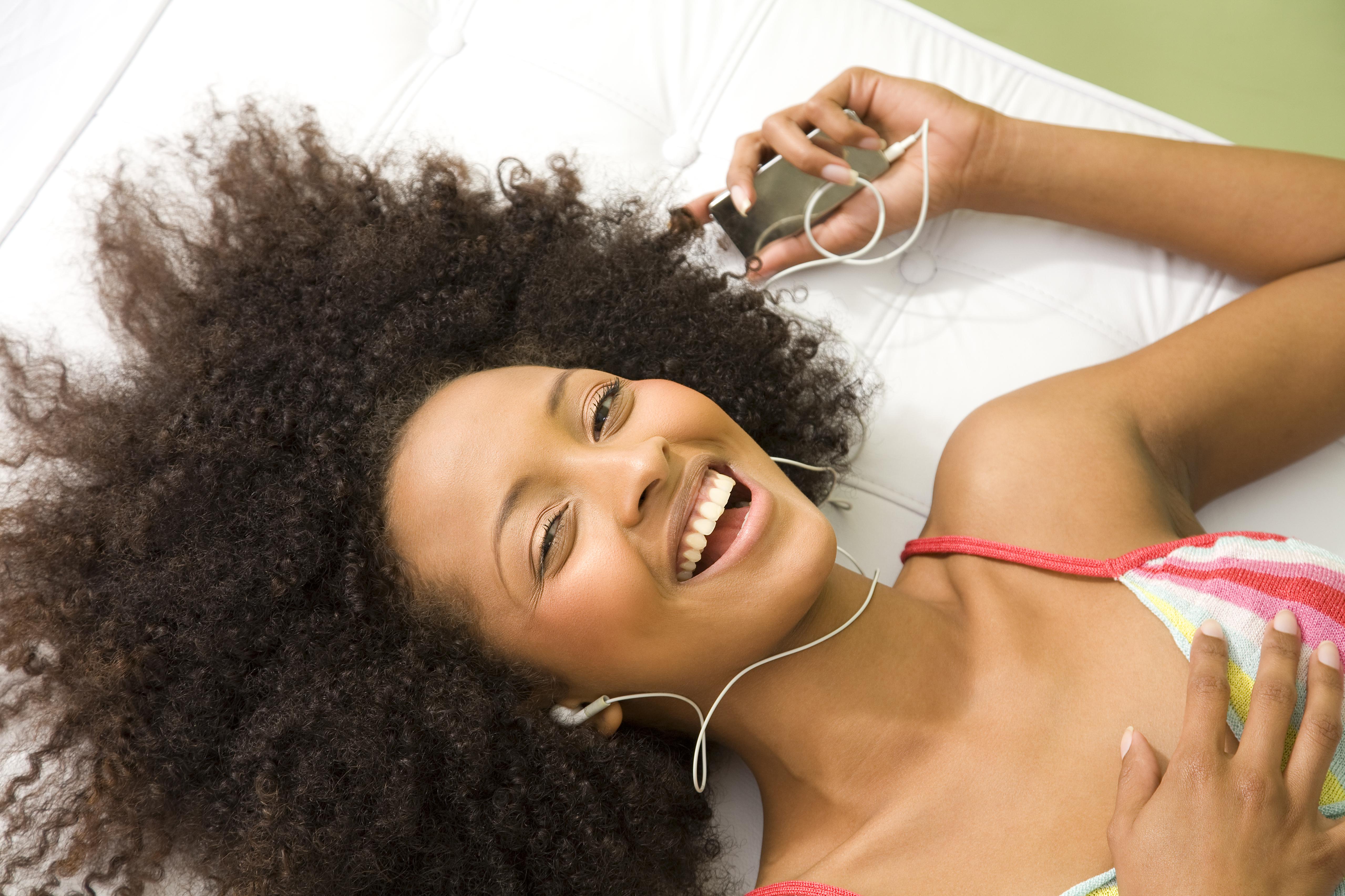 Śmiejąca się kobieta słuchająca odtwarzacza mp3