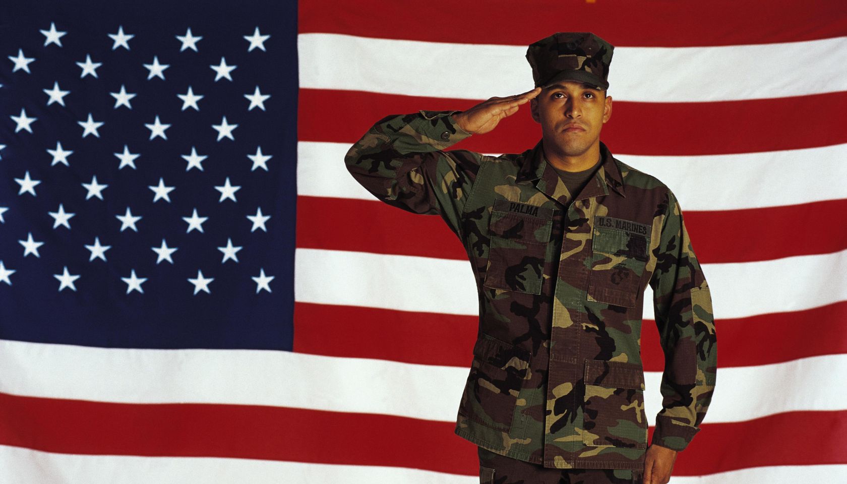 Marine saluting against American flag