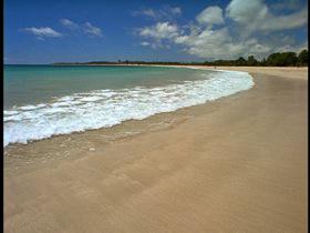 HA LS of ocean waves gently lapping onto a beach./Fiji