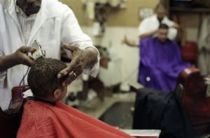 Boy getting hair cut in barber shop