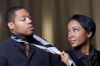 An attractive african american woman is suggestively pulling her lover's tie.