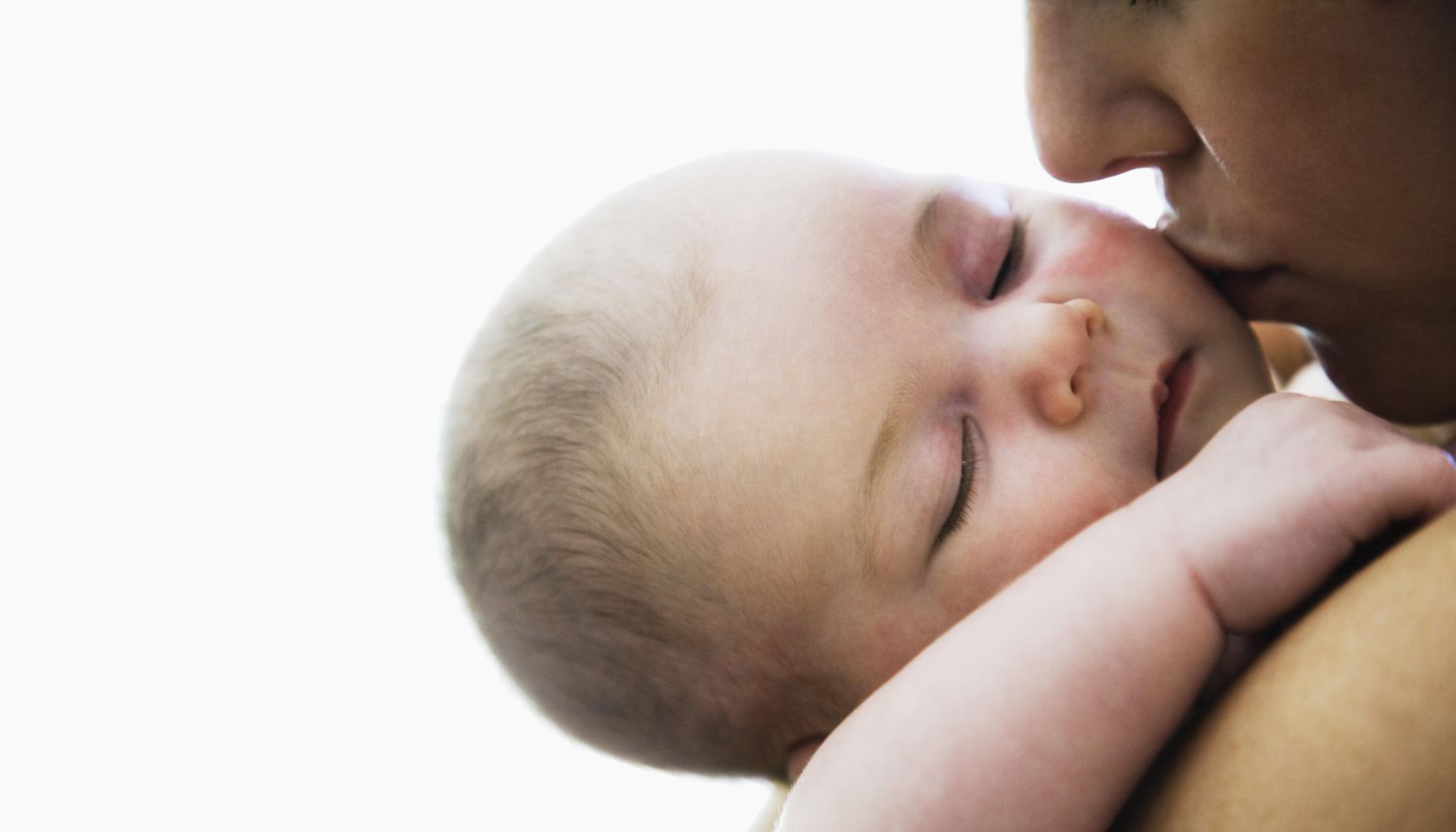Mother kissing sleeping infant