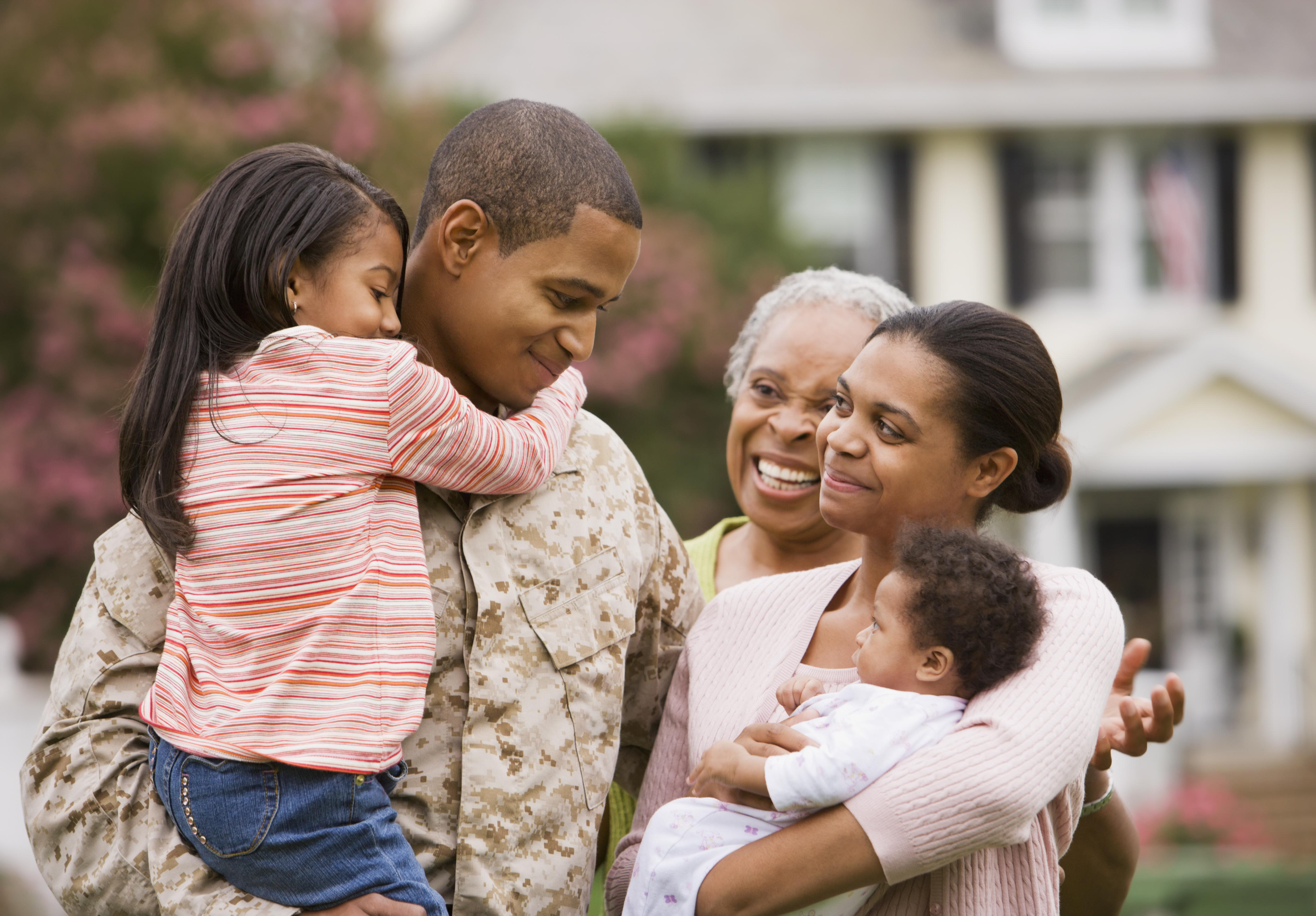 African American military father hugging family