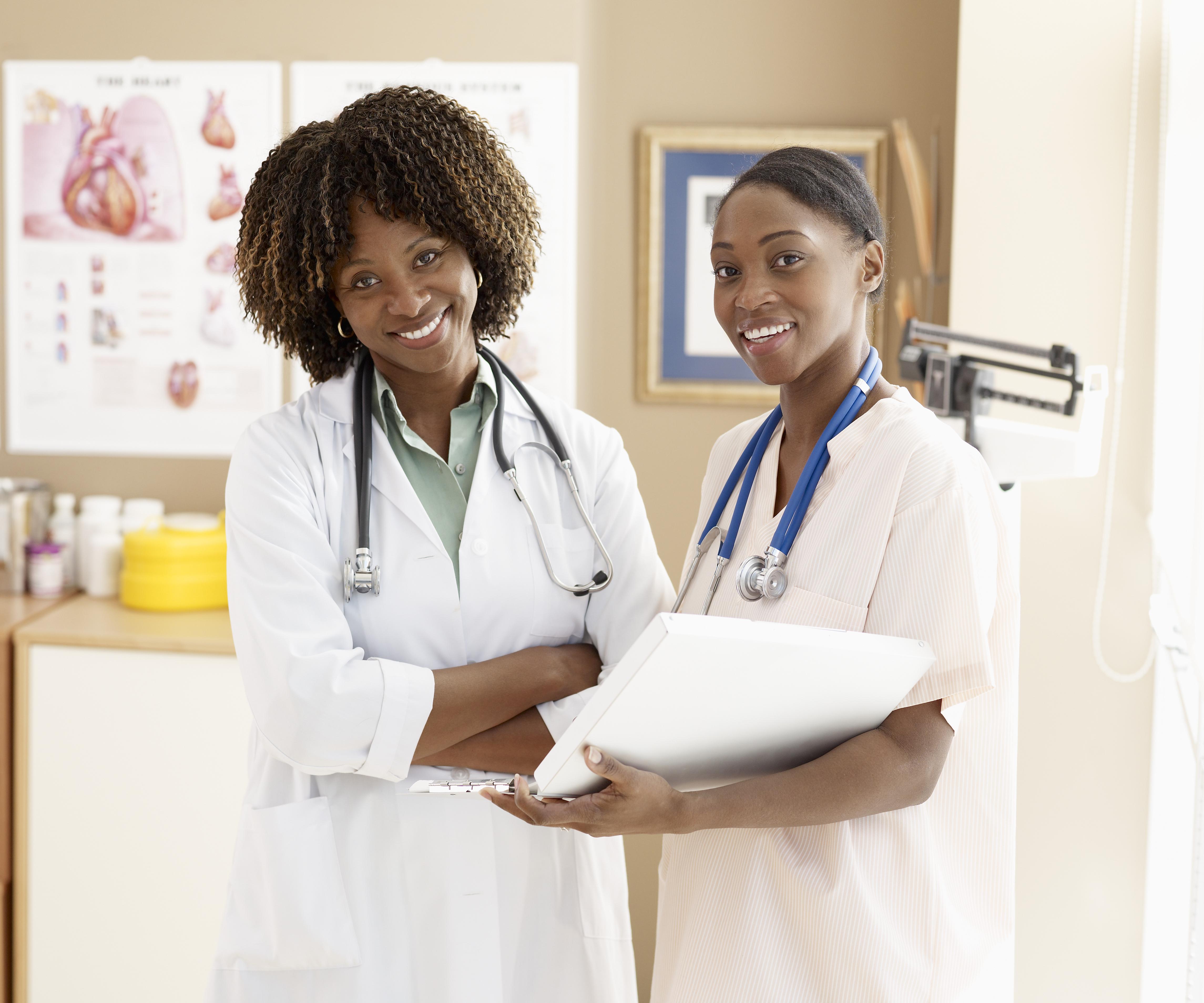 Female nurse standing with doctor, smiling, portrait
