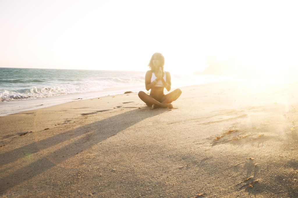 girl doing yoga on beach