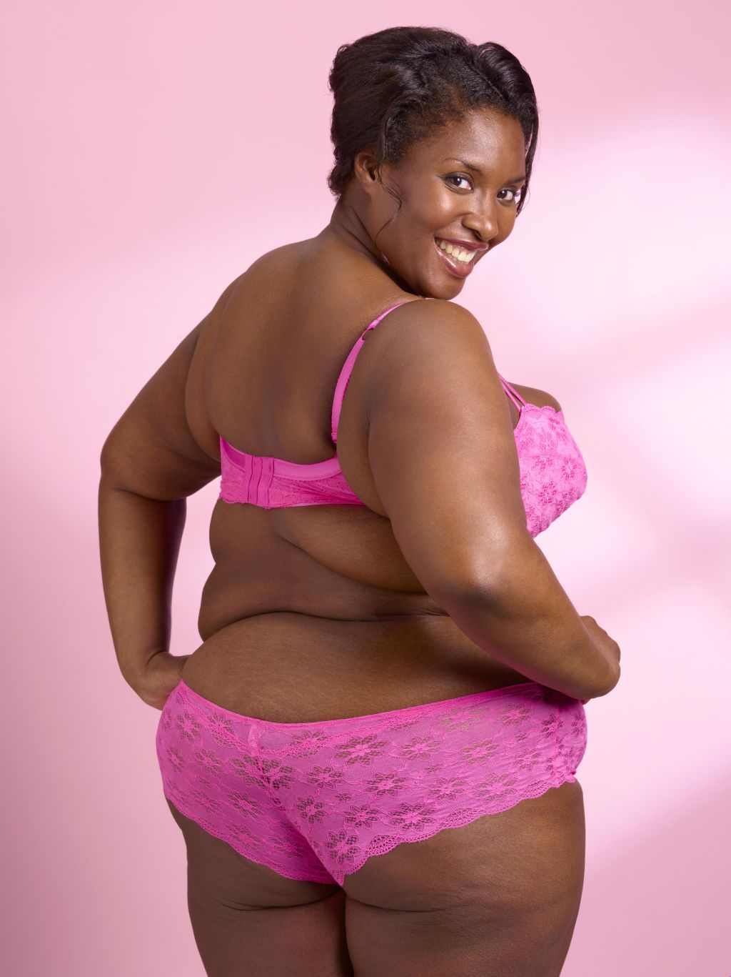 Overweight woman on pink background