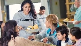 Volunteer serving healthy meal to families in food bank