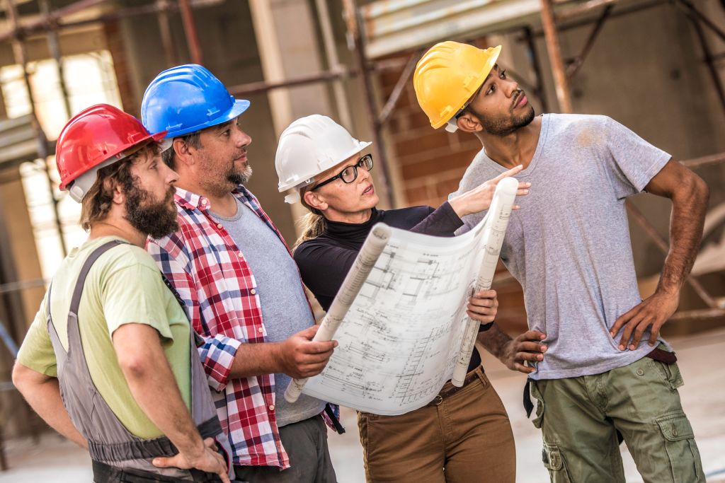 Architect explaining building plans to a group of construction workers