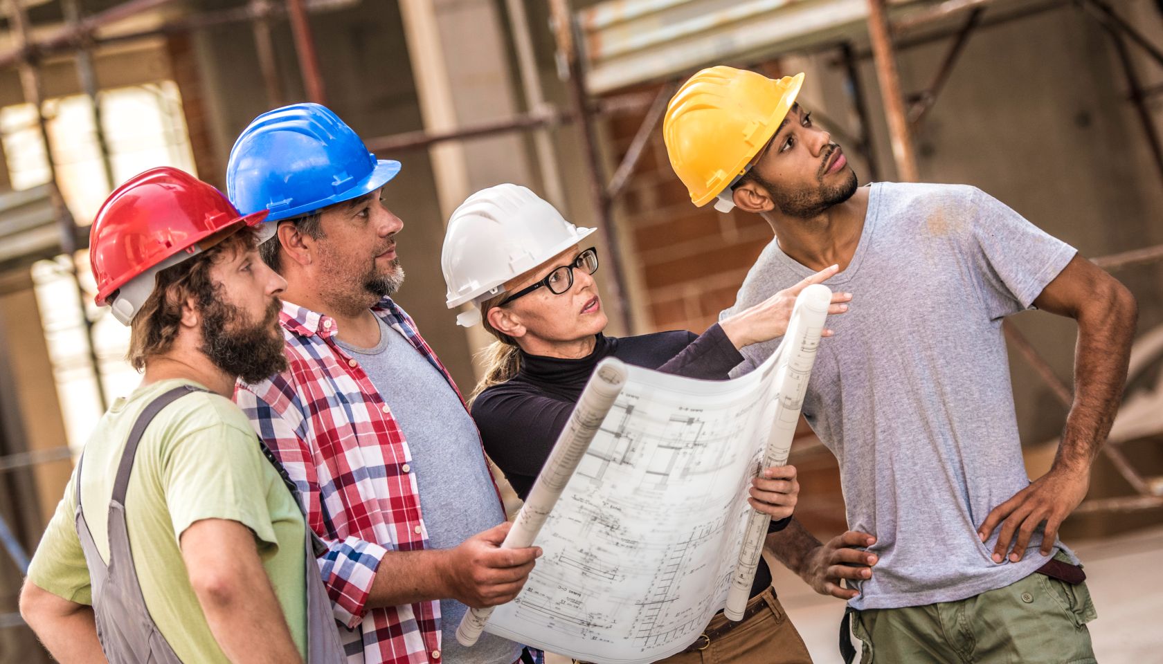 Architect explaining building plans to a group of construction workers