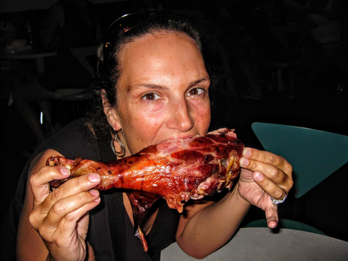 Portrait Of Woman Eating Turkey Leg At Restaurant