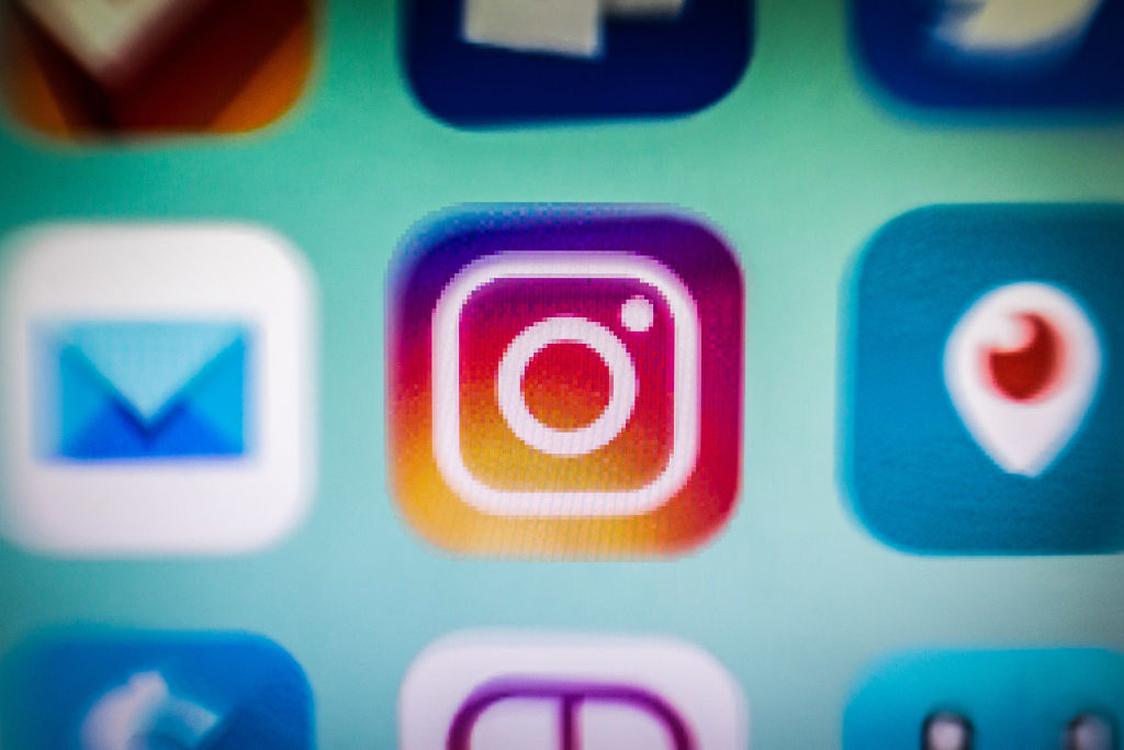 In this photo illustration, an Instagram app icon is...