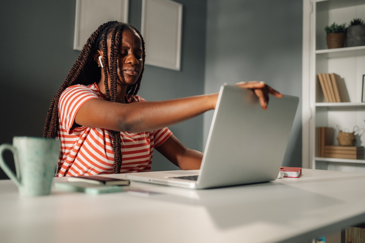 Stressed young woman closing laptop after work at home office