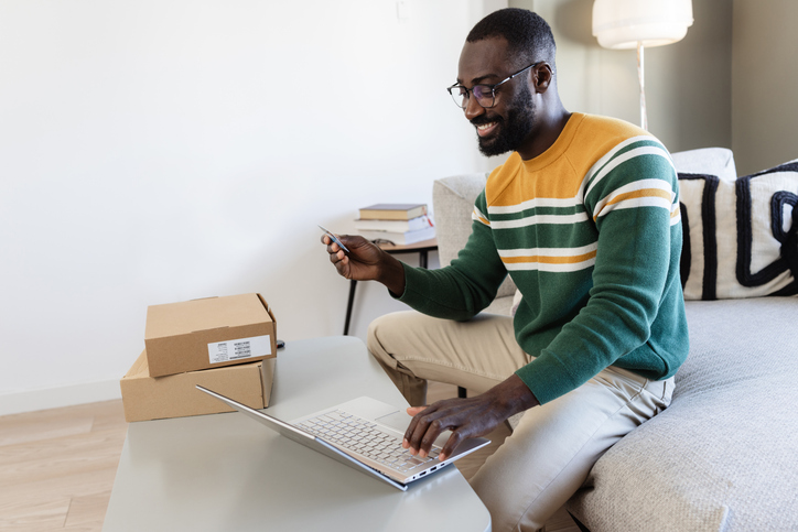 Man shopping online with laptop and credit card at home