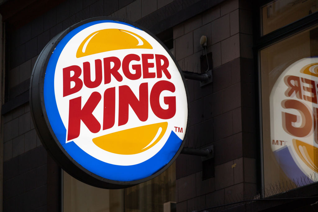 A Burger King logo is seen on the facade of a restaurant...