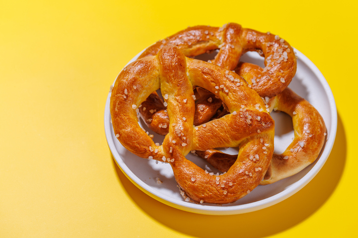 Pretzels scattered across a bright yellow background