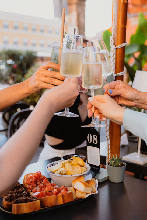 Celebratory Toast with Glasses and Appetizers on Table