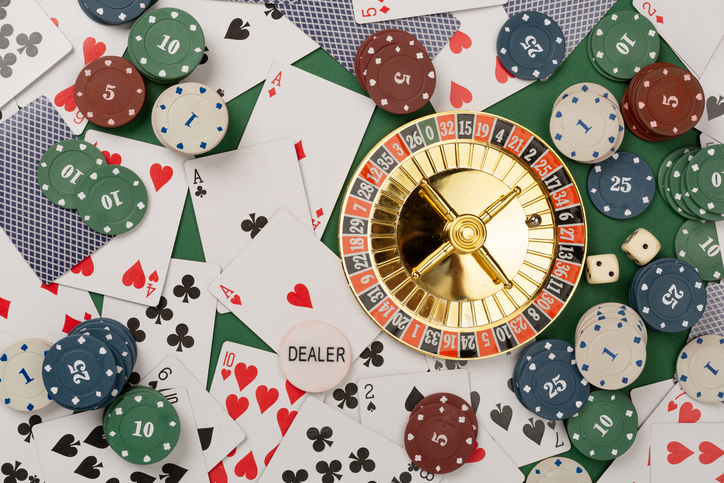 Poker chips and playing cards on color background, top view. Casino card game