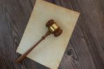 Judicial gavel resting on Vintage Parchment Paper Antique Writing and Calligraphy Concept