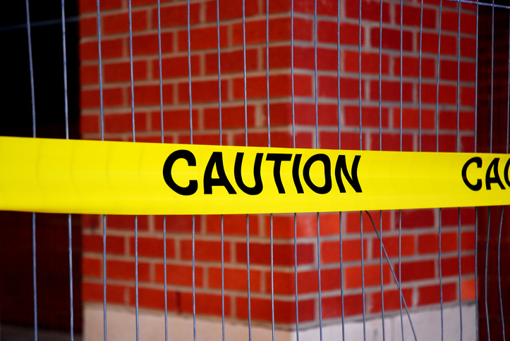 caution warning strip in front of brick wall building