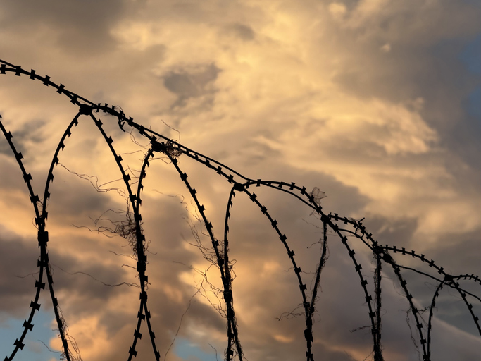 Razor wire on a fence at sunset