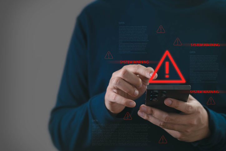 Man using smartphone with system warning alert and security notification, cybersecurity risk concept, data protection, hacking threat, digital privacy, online safety and mobile technology danger.