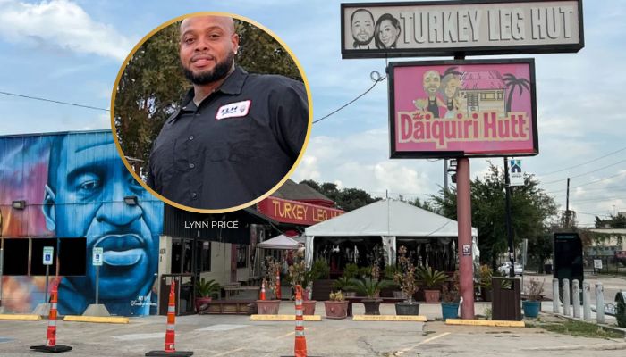 A man wearing a black shirt stands in front of a building with signs for "Turkey Leg Hut" and "Daiquiri Hutt". The building has colorful murals on the exterior.