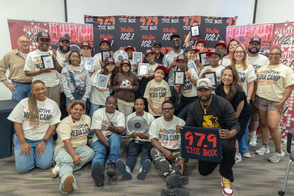 A group of people, some wearing "Majic 102.1" branded clothing, posing together in front of a backdrop with "The Box 979" branding.