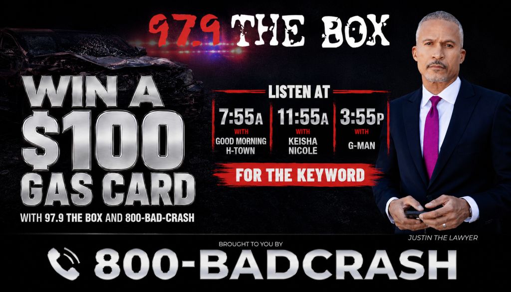 A man in a suit standing in front of a radio station advertisement for "97.9 The Box" and a $100 gas card giveaway, with call times for various radio personalities.