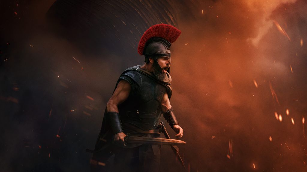 A warrior in ancient Roman armor stands in a fiery, apocalyptic landscape, with a massive, winged creature looming in the background. The text "THE ODYSSEY 07.17.26" is displayed.