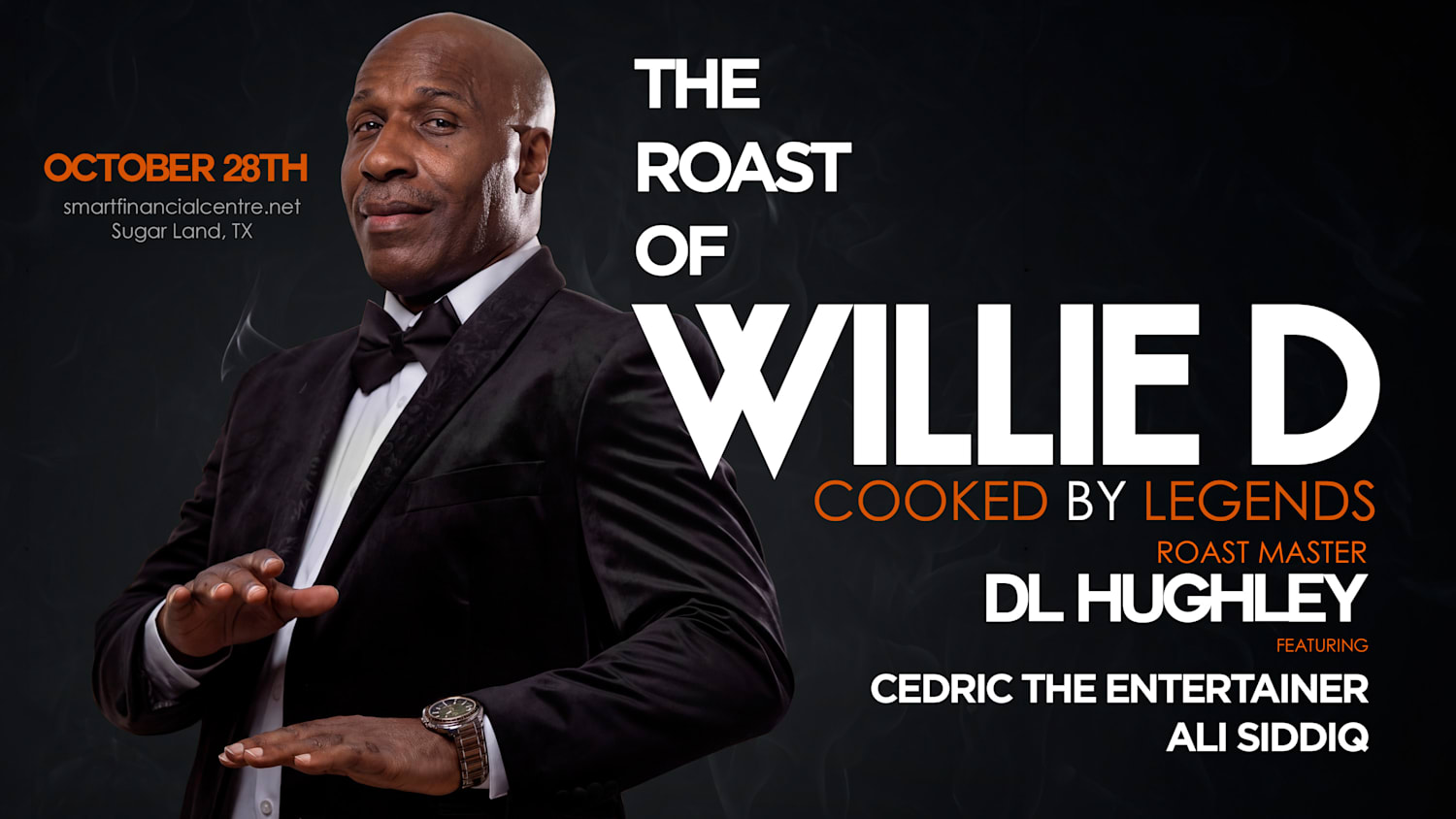 A well-dressed man in a suit and tie, standing in front of a promotional poster for "The Roast of Willie D" event on October 28th in Sugar Land, TX.