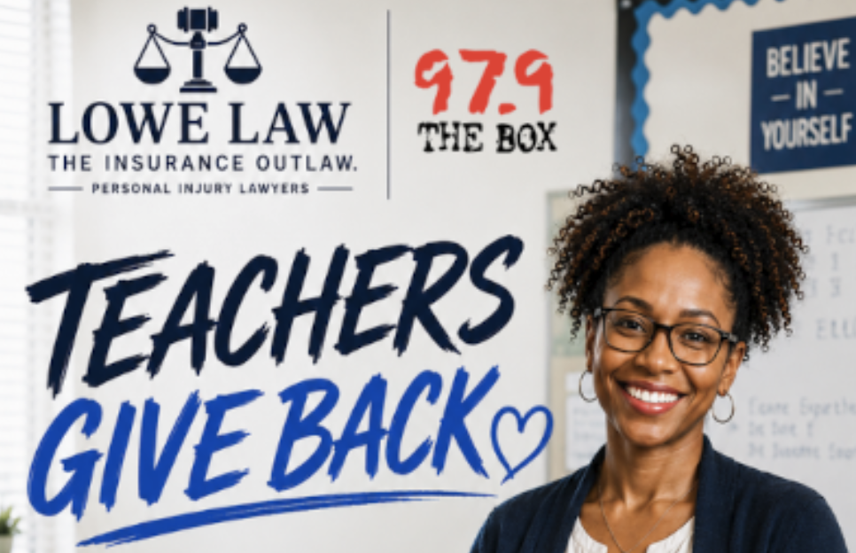 A smiling woman with curly hair wearing glasses stands in front of signs for "Lowe Law" and "The Box 97.9" with text reading "Teachers Give Back".